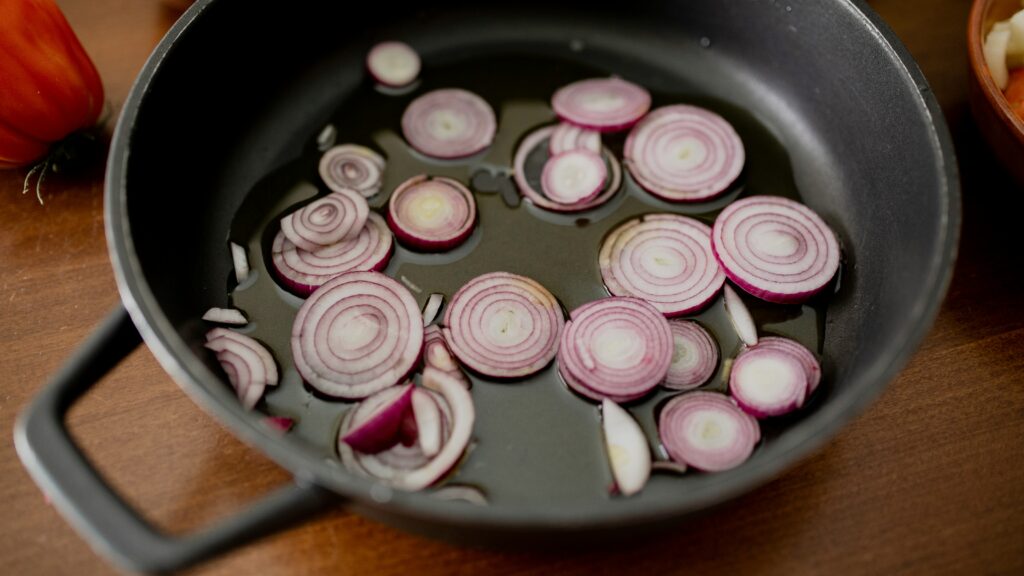 Red onions cooking in a pan
