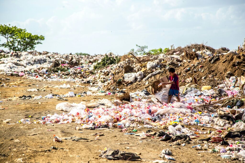 Kid standing amongst a patch of garbage