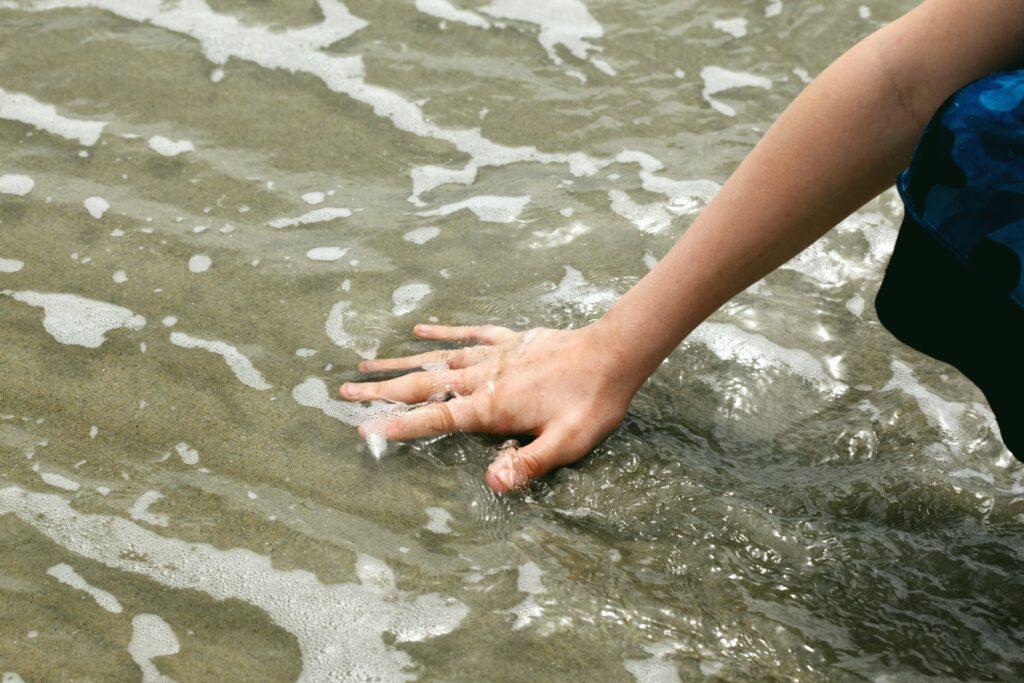 Person putting their hand into the ocean